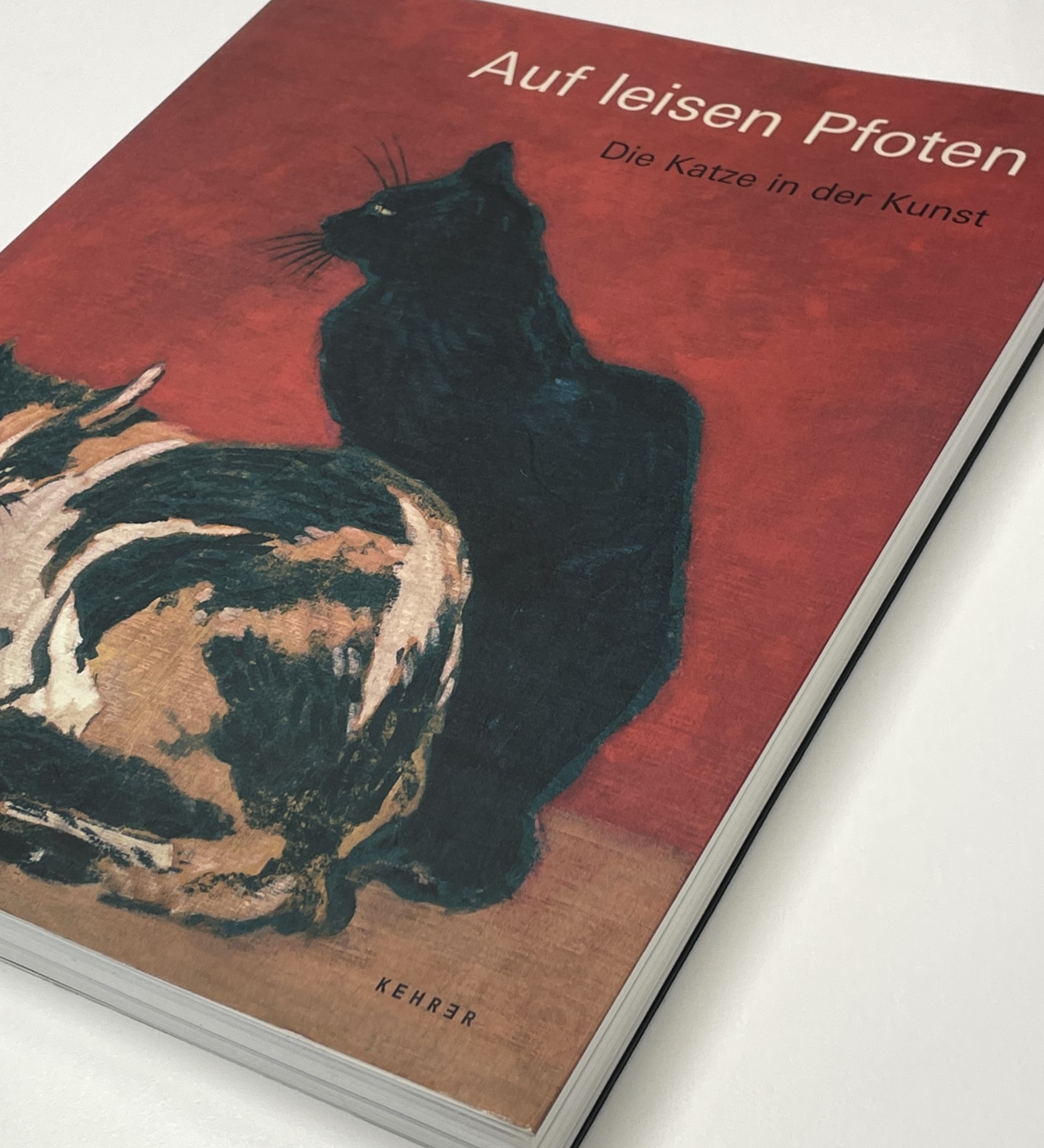 Foto des Ausstellungskatalogs mit Darstellungen von Katzen auf dem Cover